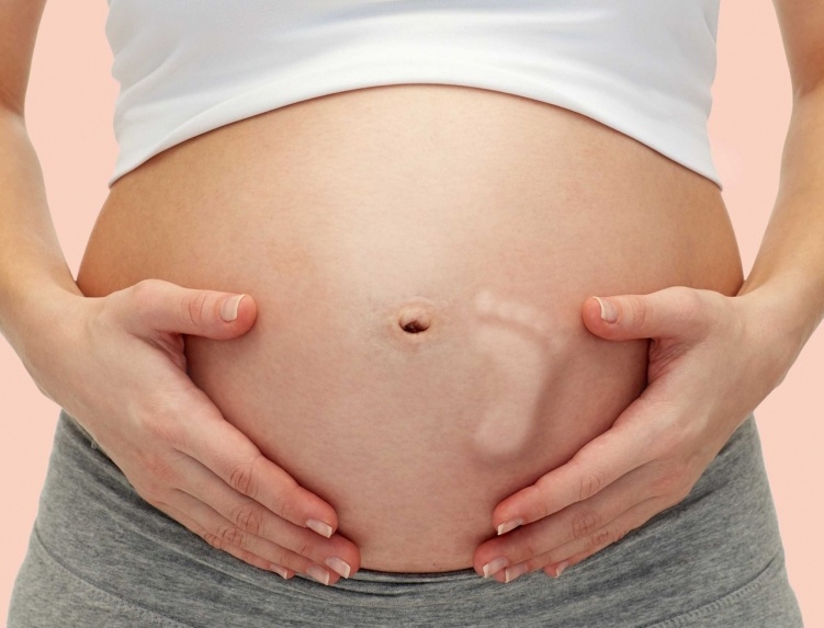 Беременная женщина и календарь с неделями беременности