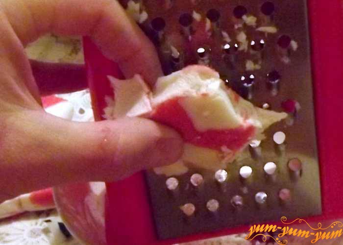 Замороженное крабовое мясо натираем на терке