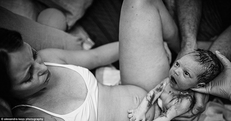 A mother watches her baby take its first breaths in a picture titled 