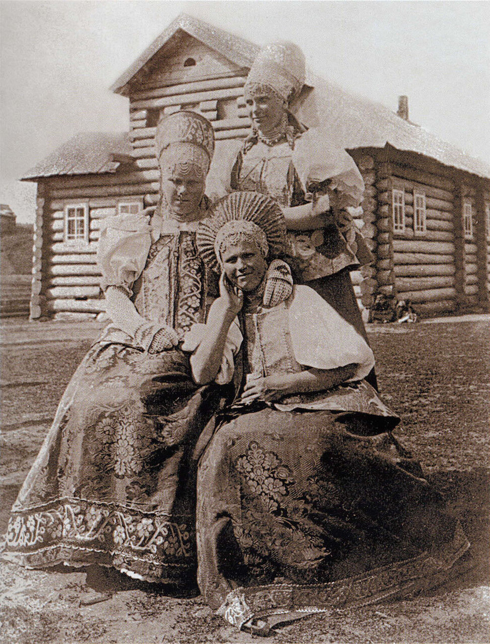 Молодая женщина и девушки в повязках в селе Ненакса (Русский Север). Начало XX века