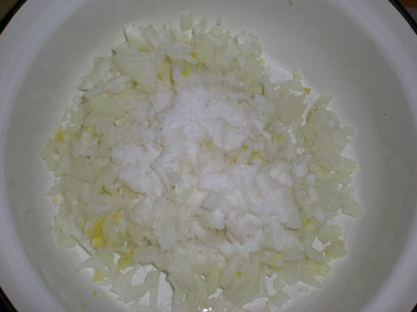 Измельчённый репчатый лук с солью в миске