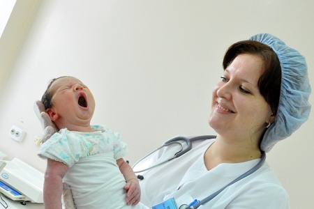 Акушерка с новорожденным: во время родов необходимо выполнять указания акушера