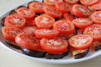 Помидоры круглыми срезами выложены на обжаренные баклажаны