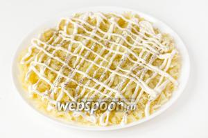 Теперь собираем сам салат. На плоское широкое блюдо выкладываем первым слоем натёртый картофель, делаем майонезную сетку, слегка солим и перчим первый слой. 