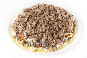 Следующий слой — свиной нарезанный язык, который посыпаем щепоткой соли и слегка перчим.