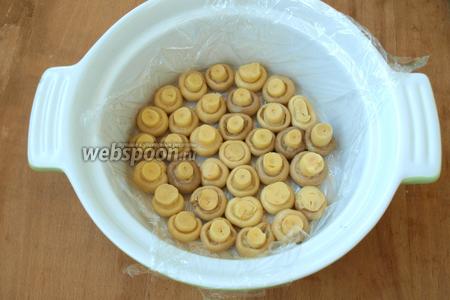 Взять подходящую форму для формирования салата, застелить её пищевой плёнкой, выложить шампиньоны шляпками вниз.