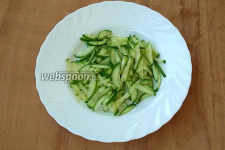 Нарезать соломкой огурец.
