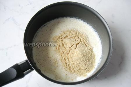 В кастрюлю налить сливки. У меня 10%, но можно взять 15%. Большей жирности брать не советую, будут котлеты жирными. Нагреть сливки, чтобы они стали горячими и всыпать панировочные сухари.