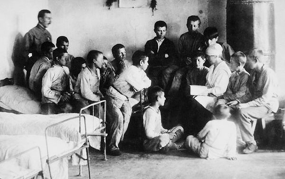 Чтение в спальне колонистов. Слева стоит А. С. Макаренко. 1921 г. 
