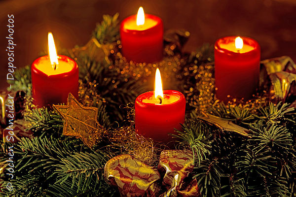 Photo of a Christmas wreath with four candles burning