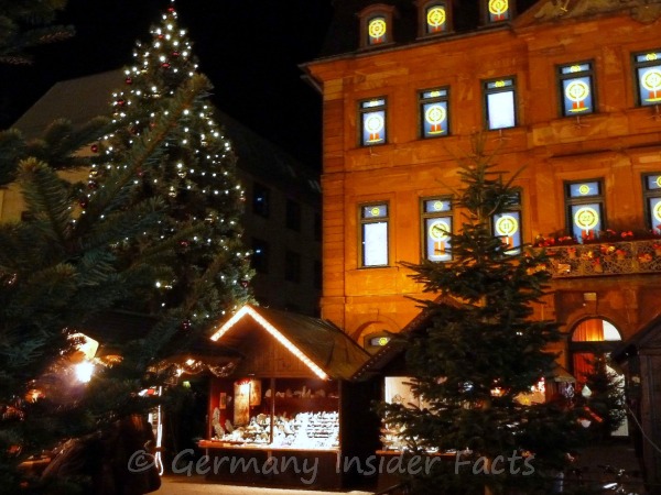 Photo of a Christmas tree, decorated Christmas stalls in front of the town hall in Hanau.